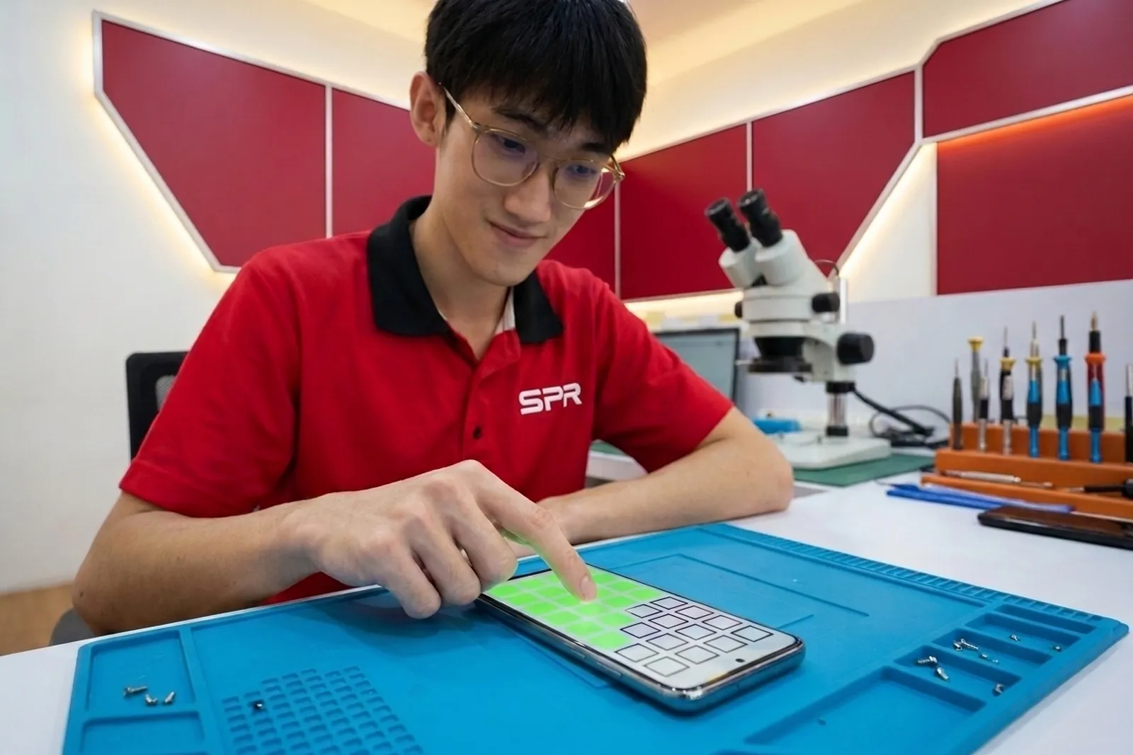 Technician running a touch grid test on an iPhone screen